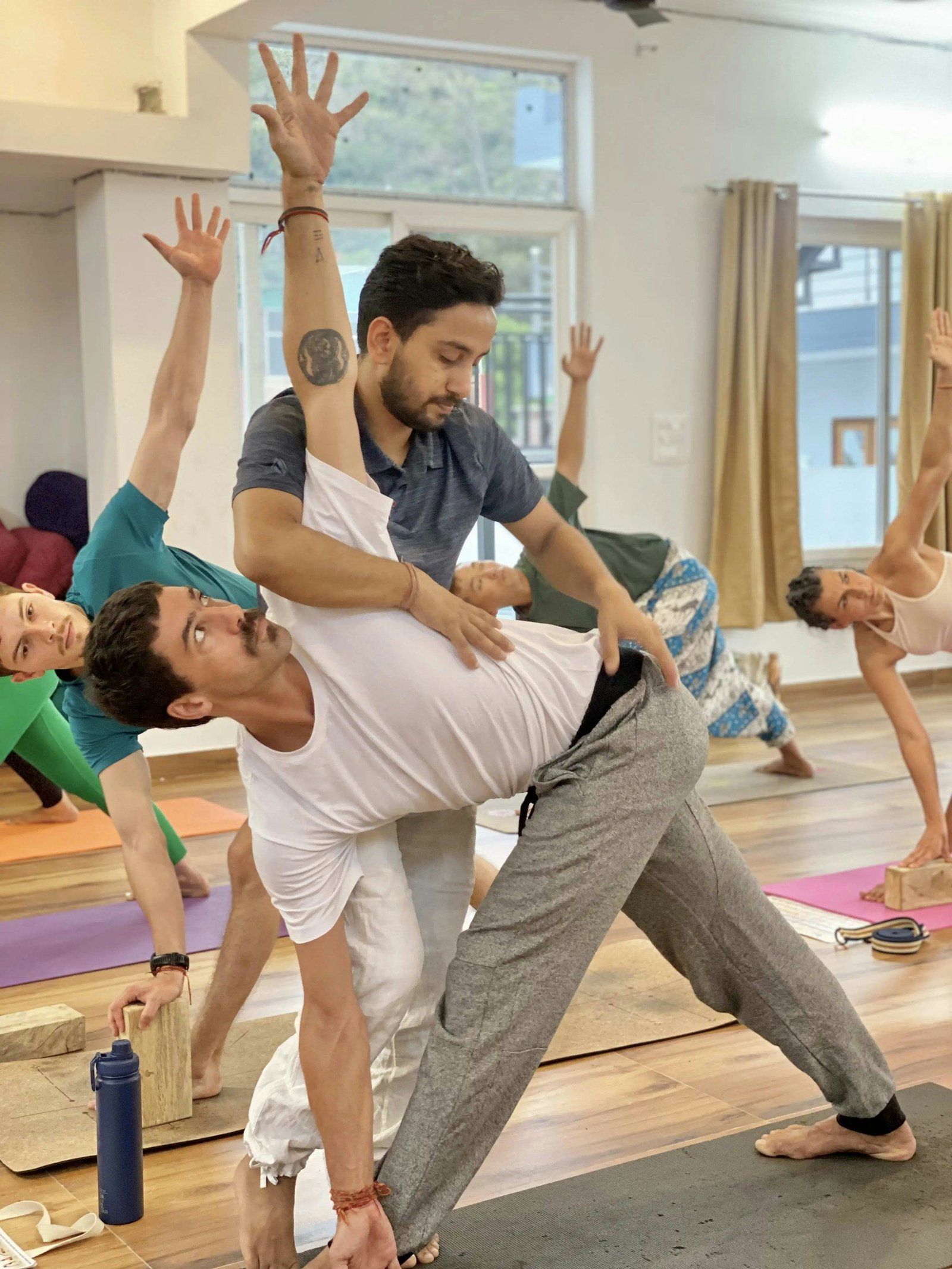 Yoga instructor guiding a participant’s posture